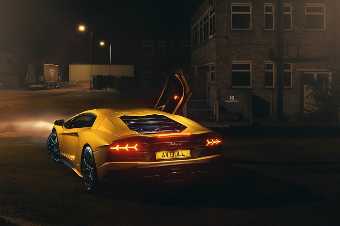 Yellow Lamborghini Aventador with doors open at night