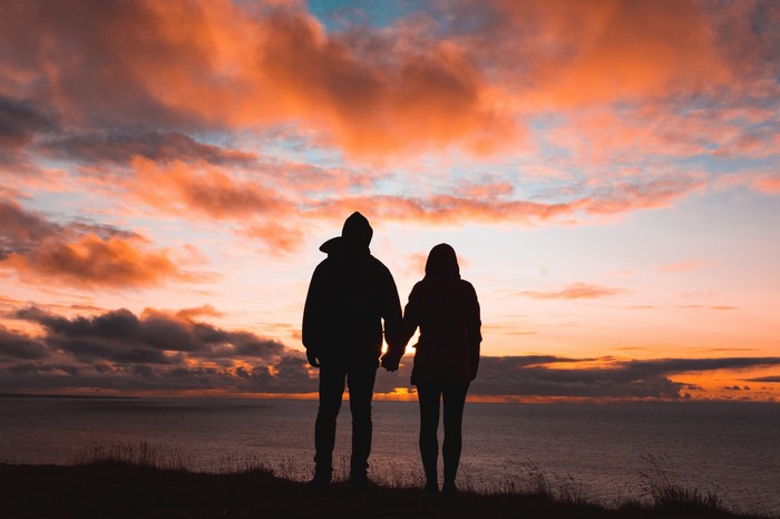 Couple holding hands at sunset