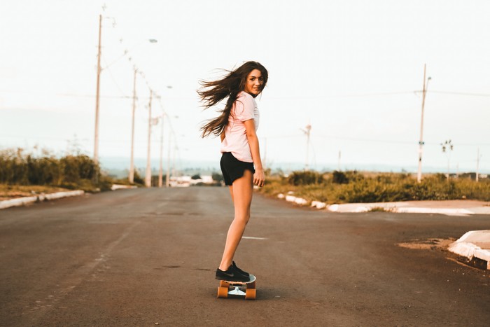 Girl skateboarding on a road
