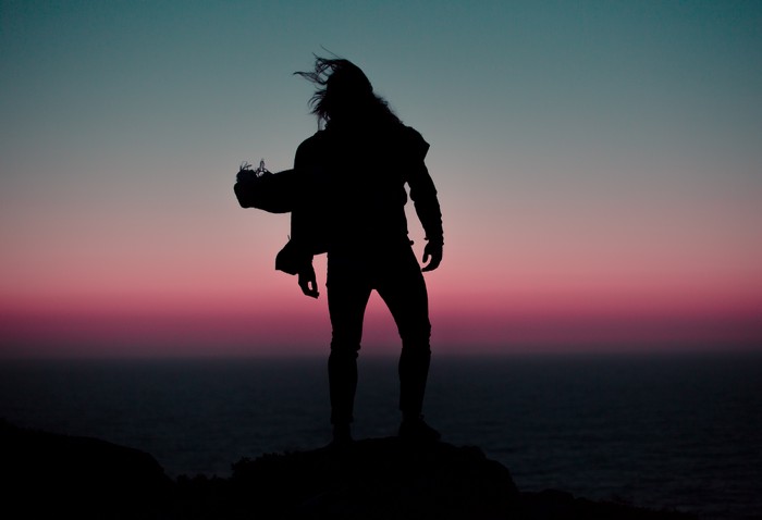 Silhouette of a man on a cliff at sunset