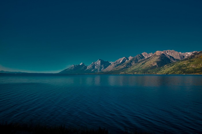 Lake and mountains under a clear blue sky