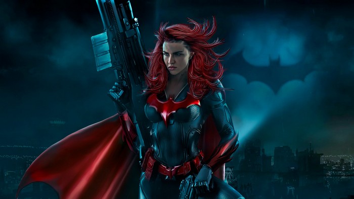 Batwoman with a gun and red cape