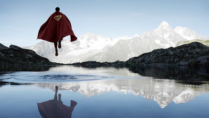 Superman flying over a mountain lake