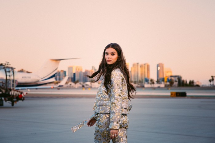 Hailee Steinfeld on an airport tarmac with a private jet