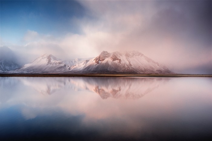 Snow-capped mountains reflected in a calm lake