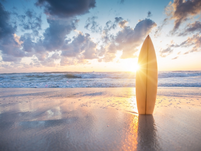 Surfboard on a beach at sunset