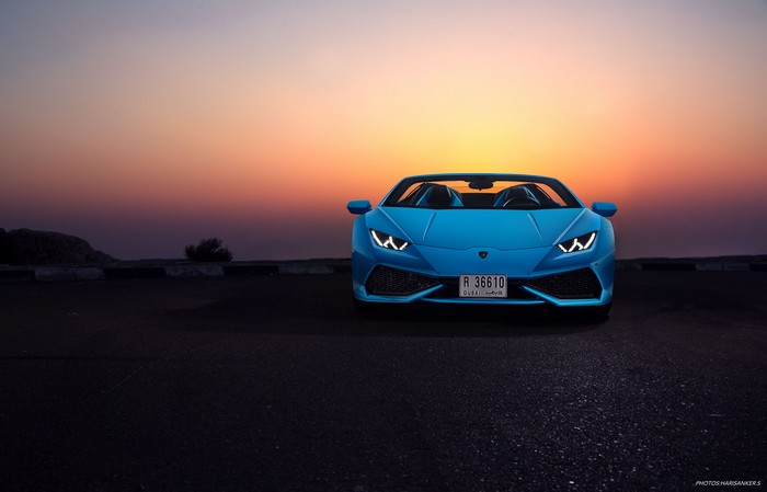 Blue Lamborghini Huracan convertible at sunset