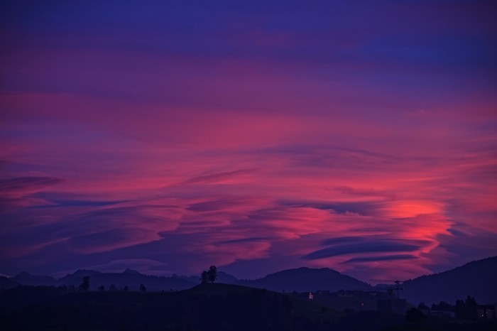 Pink and purple clouds over mountains at dusk 4K