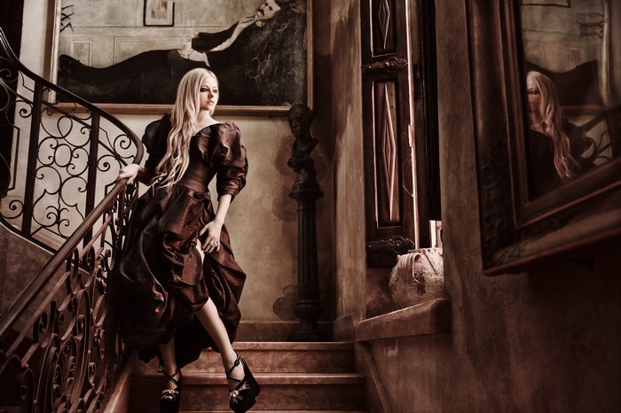 Avril Lavigne posing on a grand staircase