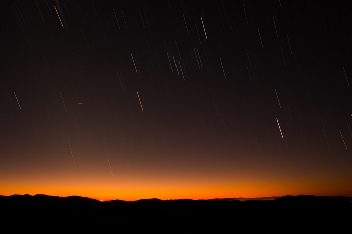 Star trails over mountains at sunset