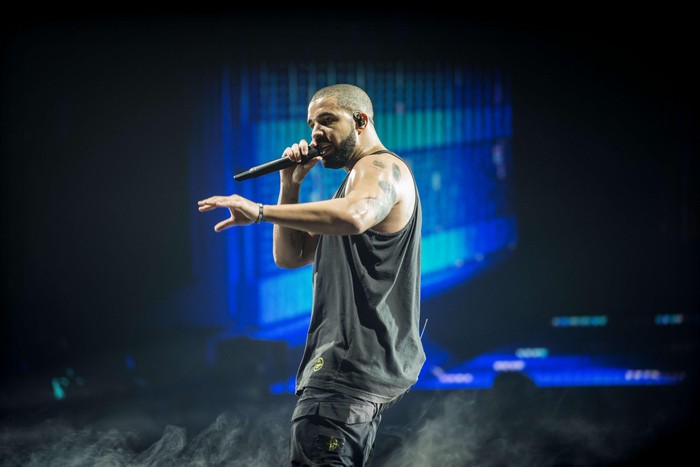 Drake performing on stage with microphone