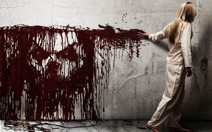 Girl touching bloody wall with skull face