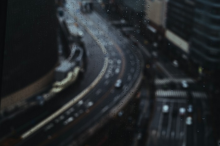 Raindrops on glass overlooking a busy highway