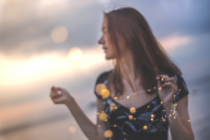 Girl with bokeh effect and fairy lights 4K