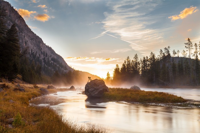 Sunrise over a misty river in a national park