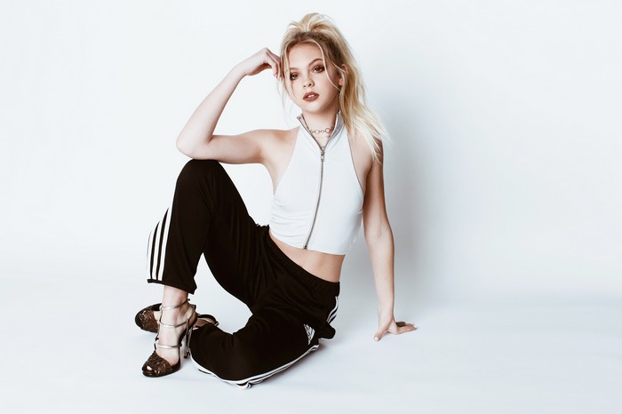 Jordyn Jones in white top and black Adidas pants