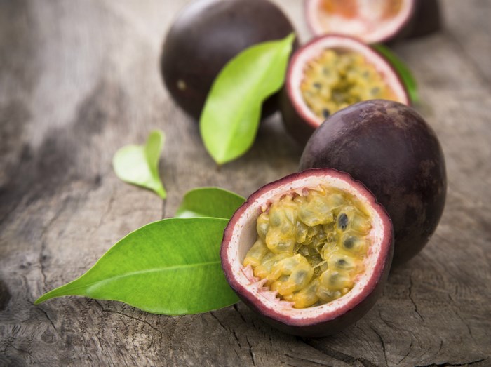 Passion fruits and leaves on wooden background