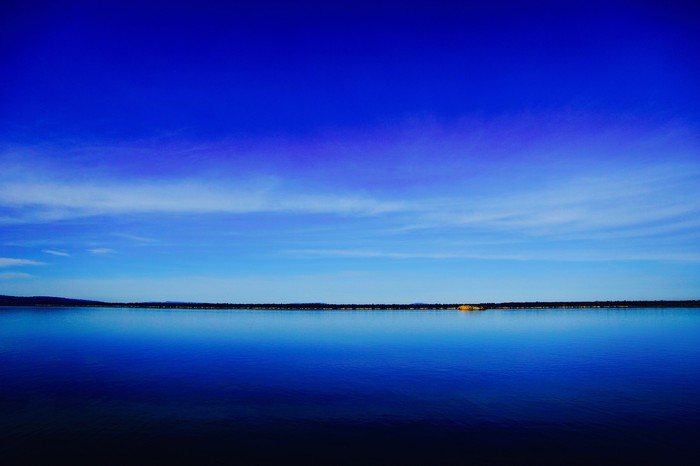Vast blue lake under a bright blue sky