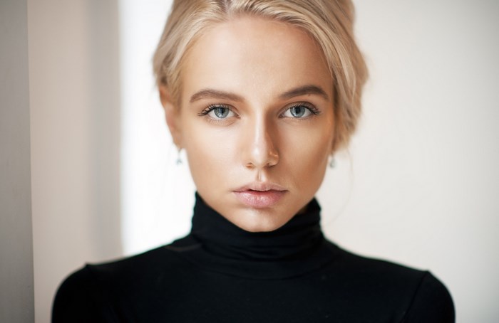 Woman with blonde hair wearing a black turtleneck
