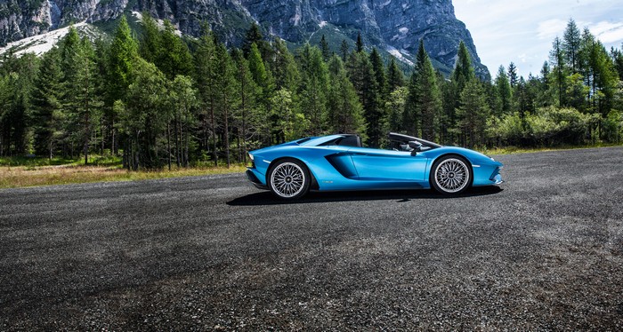 Blue Lamborghini Aventador S convertible on a mountain road