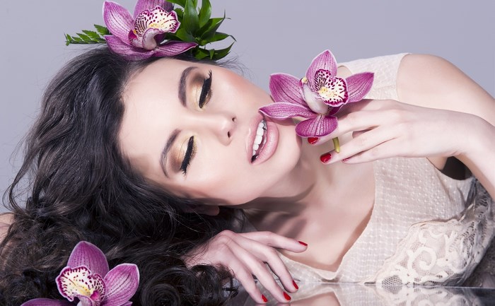Woman with Purple Orchids and Elegant Makeup