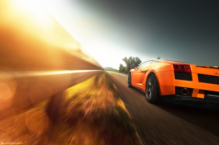 Orange Lamborghini driving on a road