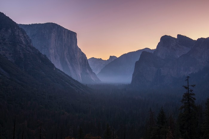 Yosemite Valley mountains at sunrise with fog