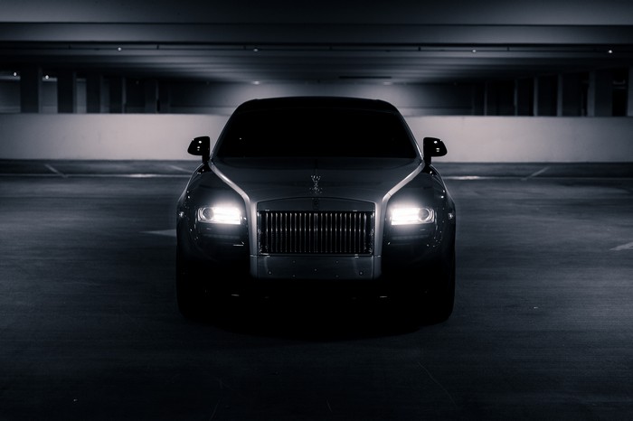 Rolls-Royce car with headlights on in a parking garage