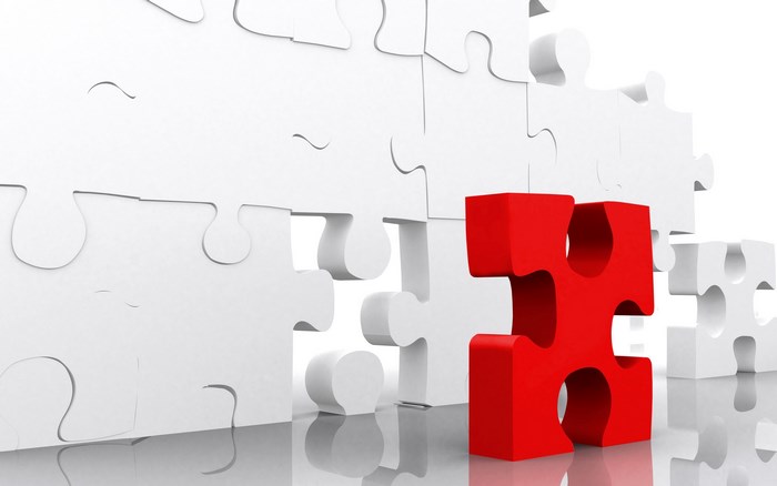 Red puzzle piece standing out from white puzzle pieces
