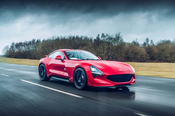 Red TVR Griffith driving on a wet road