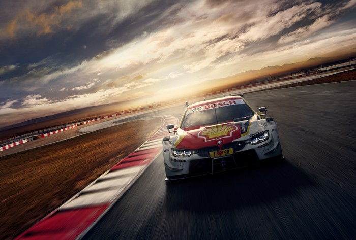BMW M4 DTM race car on a track at sunset