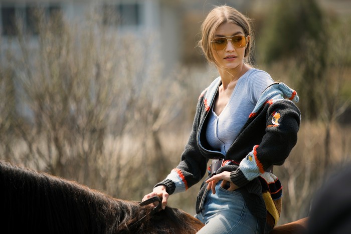 Gigi Hadid on a horse wearing sunglasses