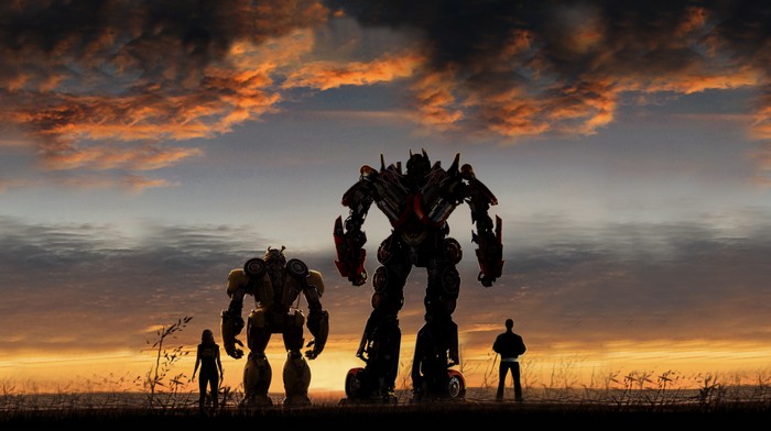 Bumblebee and Optimus Prime silhouetted against sunset