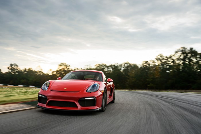 Red Porsche Cayman driving on a race track
