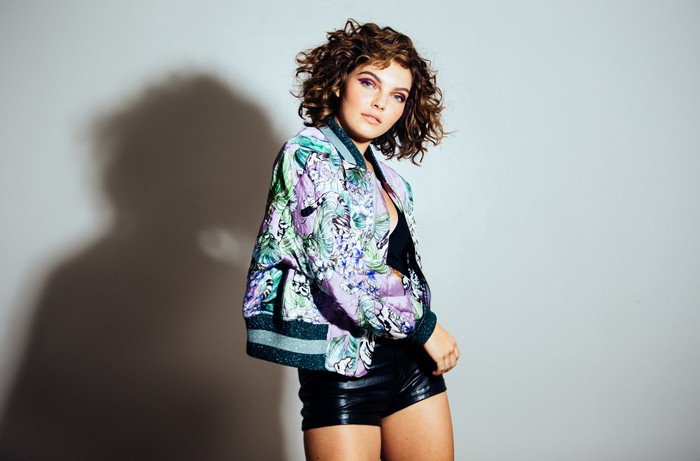 Camren Bicondova in a floral bomber jacket and leather shorts