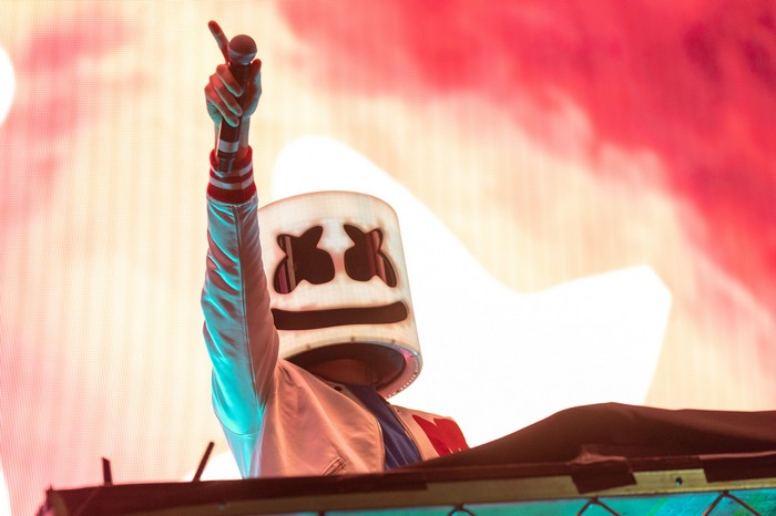 Marshmello performing on stage with a microphone