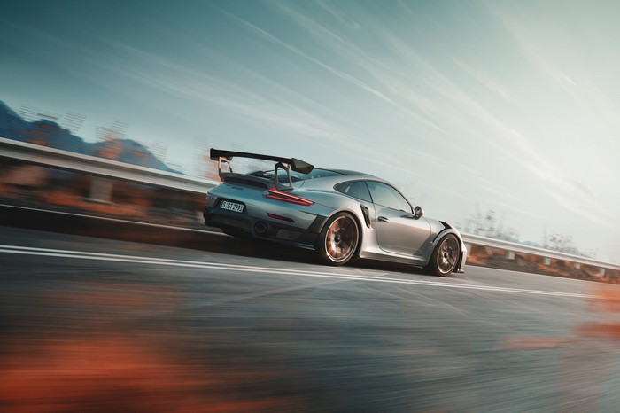Silver Porsche 911 GT2 RS driving on a road
