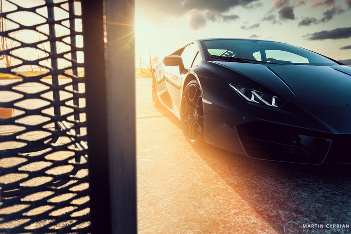 Black Lamborghini Huracan parked outdoors at sunset