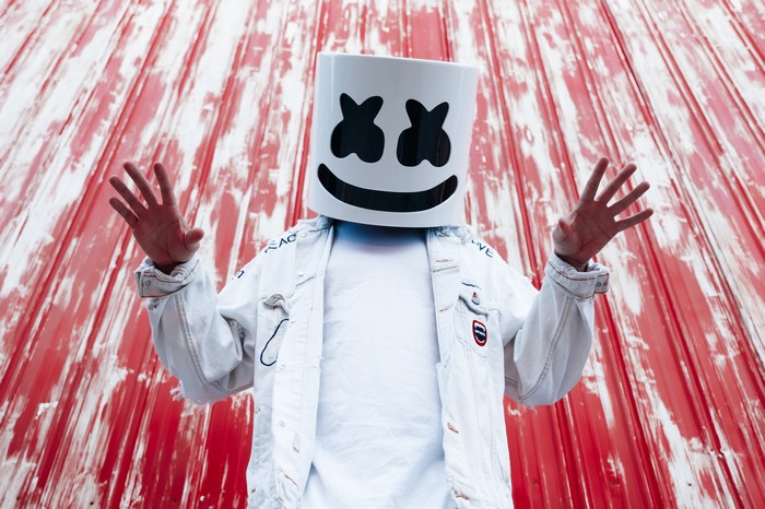 Marshmello DJ in white jacket against red background
