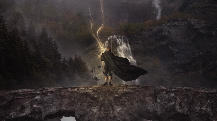 Black Adam conjures lightning near a waterfall