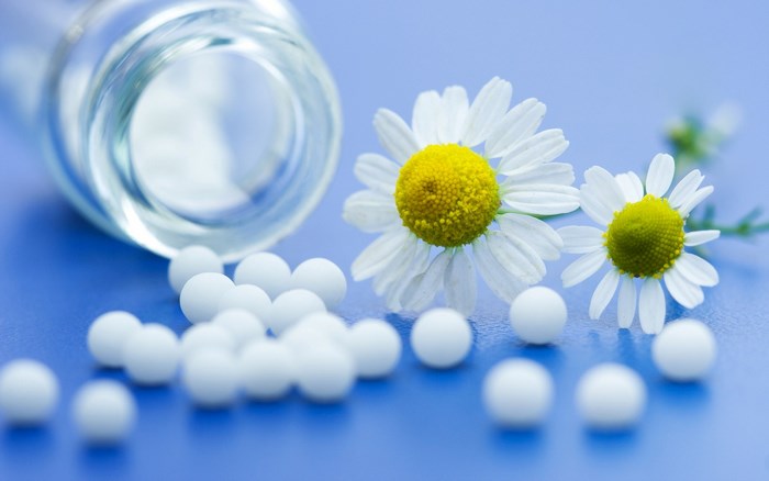 Chamomile Flowers and White Pills on Blue Surface
