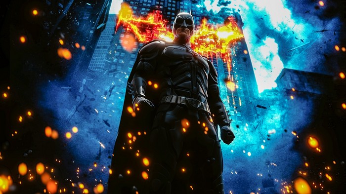 Batman standing in a burning city