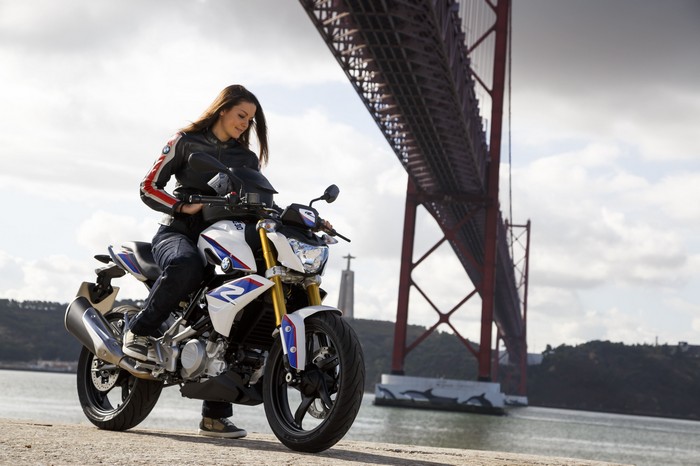 Woman on a BMW G310 R motorcycle under a bridge