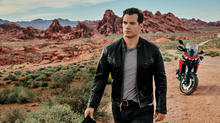 Henry Cavill in a desert landscape with a motorcycle