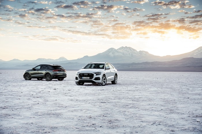 Two Audi Q8 SUVs in a desert landscape
