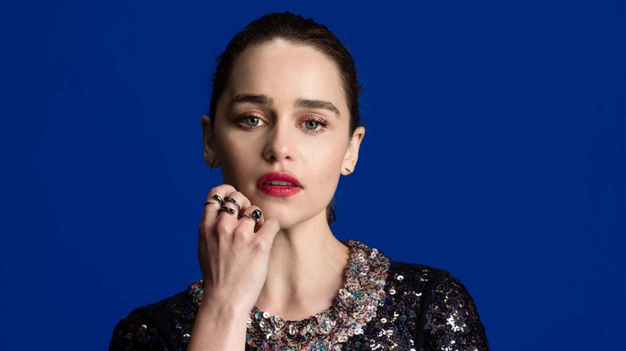 Emilia Clarke posing against a blue background