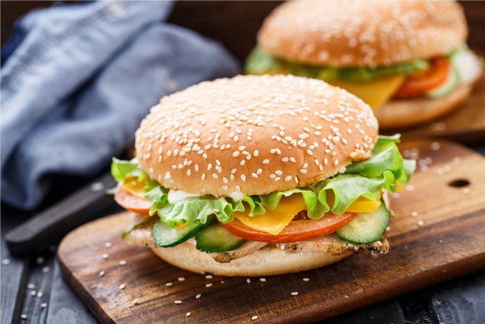 Two gourmet burgers on wooden boards
