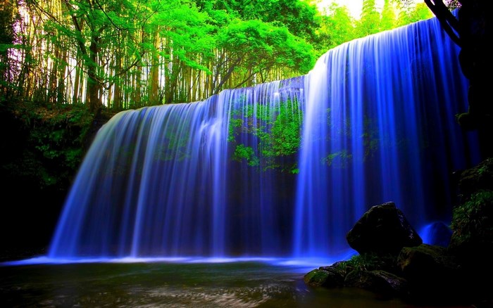 Serene Blue Waterfall Flowing Through Green Forest