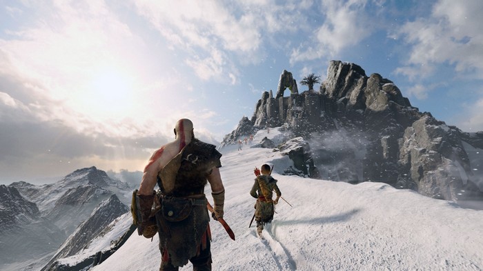 Kratos and Atreus walk through a snowy mountain landscape