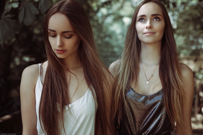Two young women with long brown hair outdoors